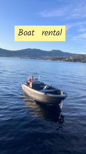 a boat in the middle of a body of water at Charming house located by the fjord with the Pultpitrock within short distance in Strand