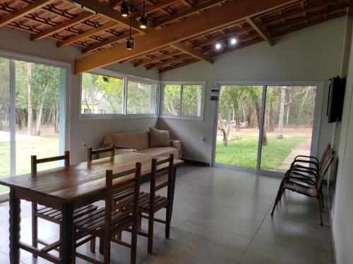 a dining room with a table and a couch at Casa na Pousada Hortelã Pimenta in Itirapina
