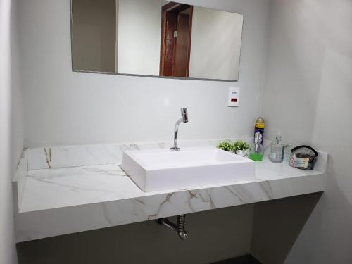 a bathroom with a white sink and a mirror at Casa na Pousada Hortelã Pimenta in Itirapina