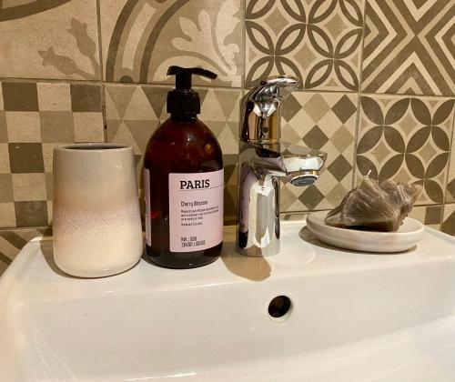 - un lavabo avec une bouteille de savon et une bougie dans l'établissement Gîte du Cap Romain, à Bernières-sur-Mer