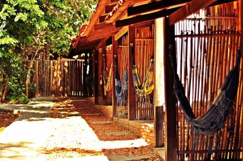 a fence with a hammock hanging from it at TEMPLÁRIOS ECOVILLA Pousada in Pirenópolis
