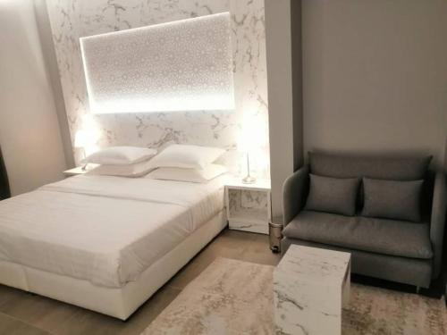 a bedroom with a white bed and a chair at غرفة فاخرة مع دورة مياه ومطبخ بحي الضاحية in Arar