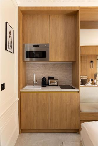 une cuisine avec un évier et un micro-ondes dans l'établissement Love room avec Jacuzzi & Cinema-Gare Mont Parnasse, à Paris