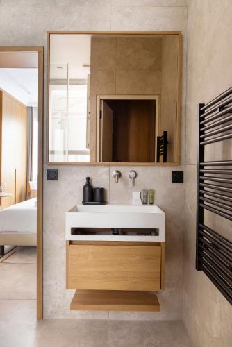 une salle de bain avec un lavabo et un miroir dans l'établissement Love room avec Jacuzzi & Cinema-Gare Mont Parnasse, à Paris