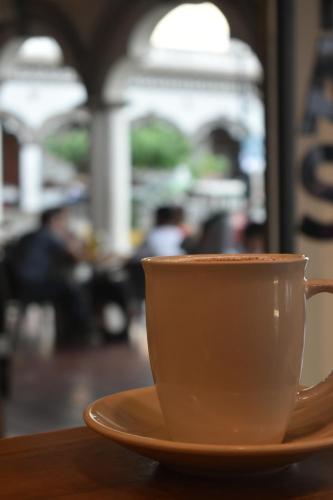 a cup of coffee sitting on a table at Comalitas Cafe y Hotel in Comala