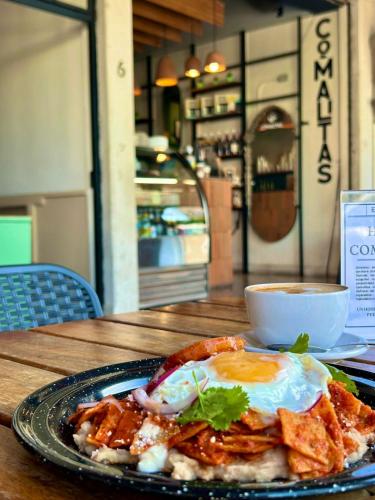 a plate of food with an egg on a table at Comalitas Cafe y Hotel in Comala