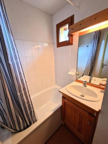 une salle de bain avec un lavabo, une baignoire et un miroir dans l'établissement Les Chalets D'arrondaz - Appartement 3 pièces 4/6 personnes 36 m² MAE-2921, à Modane