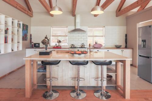 a kitchen with a large wooden island with bar stools at Robertson Stays in Robertson