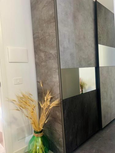 a mirror in a room with a green vase at casa turistica l'etoile in Conversano