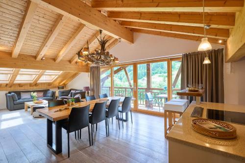 une cuisine et un salon avec une table et des chaises dans l'établissement FranceComfort - AlpResort Portes du Soleil, à La Chapelle-dʼAbondance