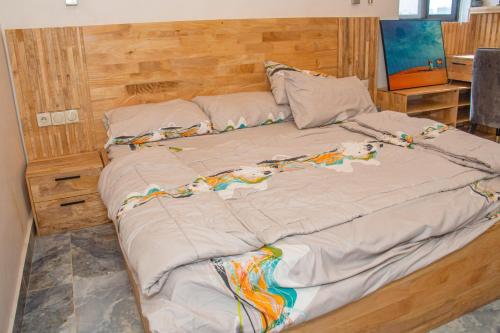 a large bed with a wooden headboard in a bedroom at RAWADE Guest house in Cotonou