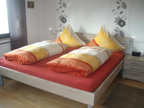 un montón de almohadas sentadas en una cama en Ferienwohnung Am Waldrand, en Bad Breisig