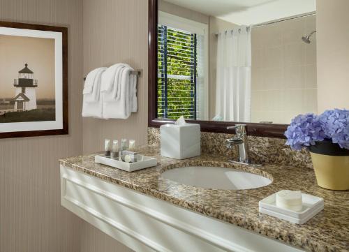 a bathroom with a sink and a mirror at Inn on the Square in Falmouth