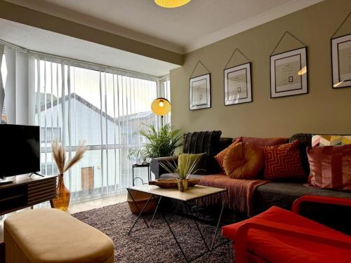 a living room with a couch and a large window at Boho Modern Entire House in Southampton - Sleeps 13 - 5 Bedrooms - 7 Beds - Overlooking the original city walls -walking Distance to the city centre & Cruise Terminals - Private garage in Southampton