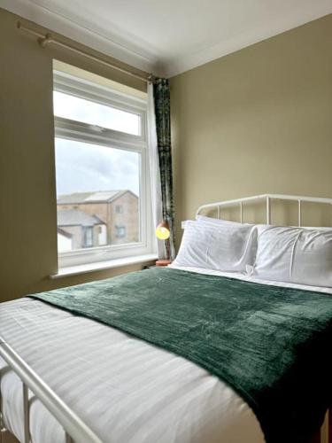 a bedroom with a large bed with a window at Boho Modern Entire House in Southampton - Sleeps 13 - 5 Bedrooms - 7 Beds - Overlooking the original city walls -walking Distance to the city centre & Cruise Terminals - Private garage in Southampton