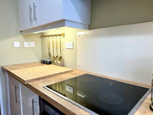 a kitchen with a counter with a stove top oven at Boho Modern Entire House in Southampton - Sleeps 13 - 5 Bedrooms - 7 Beds - Overlooking the original city walls -walking Distance to the city centre & Cruise Terminals - Private garage in Southampton