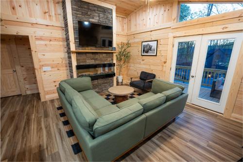 a living room with a couch and a table at The Wilderness Cabin - Shenandoah Getaway - HotTub, Arcade, RiverAccess in Shenandoah
