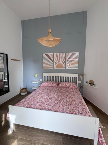 a bedroom with a large white bed with pink sheets at Maison Comì in Frattamaggiore