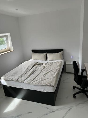 a bedroom with a bed and a desk and a chair at Gemütliche Wohnung in Heilbronn in Heilbronn