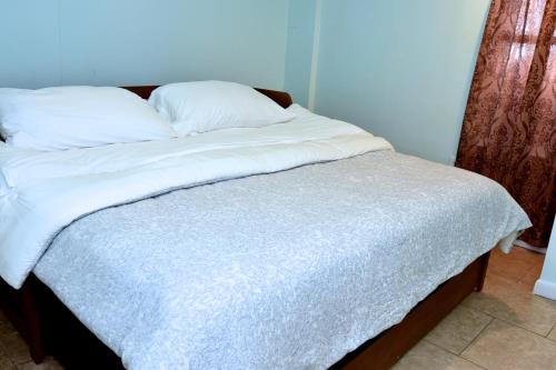 a bed with white sheets and pillows on it at Handsome Home Renovated - close to Metro in Lanham