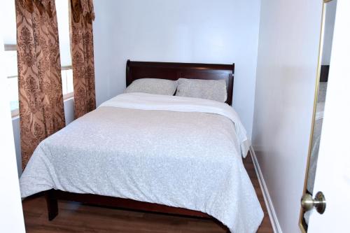 a bedroom with a bed with white sheets and pillows at Handsome Home Renovated - close to Metro in Lanham
