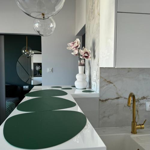 a kitchen with a green counter top with a vase of flowers at Apartament Smolna Sun in Szeląg