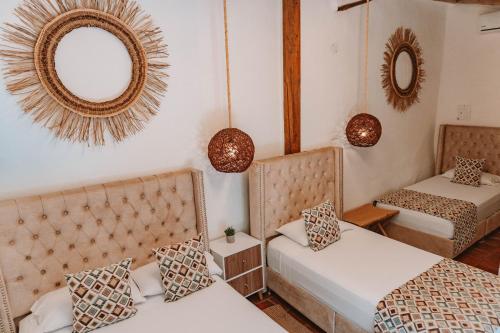 a room with two beds and two mirrors at HOTEL BOUTIQUE EL CAMPANARIO in San Gil