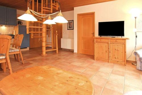 a living room with a television and a table at Wunderschöne Ferienwohnung mit Seeblick in Rechlin
