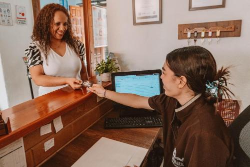 a woman standing next to a desk with a customer at HOTEL BOUTIQUE EL CAMPANARIO in San Gil