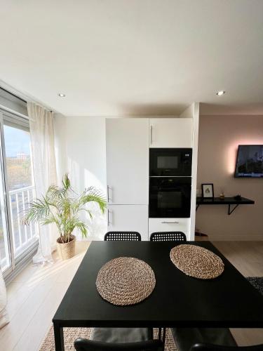 un salon avec une table et des chaises noires dans l'établissement Appartement les Falaises, au Cap d'Agde