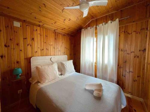 una camera con letto bianco e ventilatore a soffitto di Villa las palmeras bonita casa con piscina privada a Les tres Cales