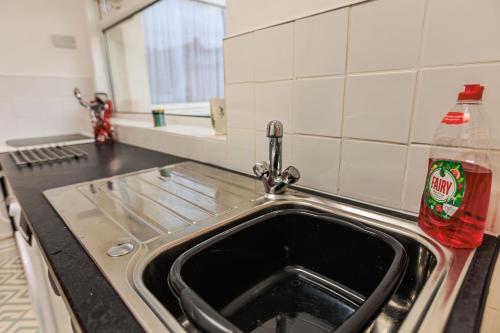 a kitchen sink with a soda bottle sitting next to it at Londonderry House in Stockton-on-Tees