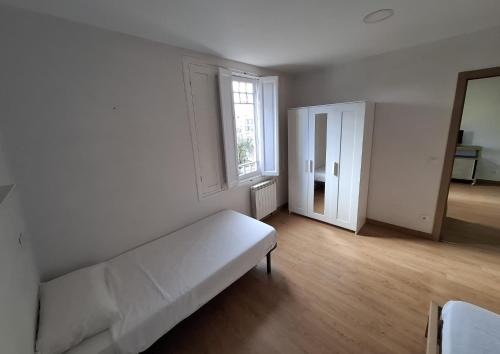 a white room with a couch and a window at La Casona Santander Centro in Santander