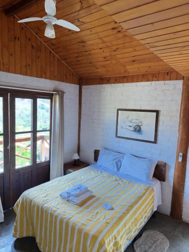 a bedroom with a bed with a ceiling fan at Solar dos Pinhais in Santo Antônio do Pinhal