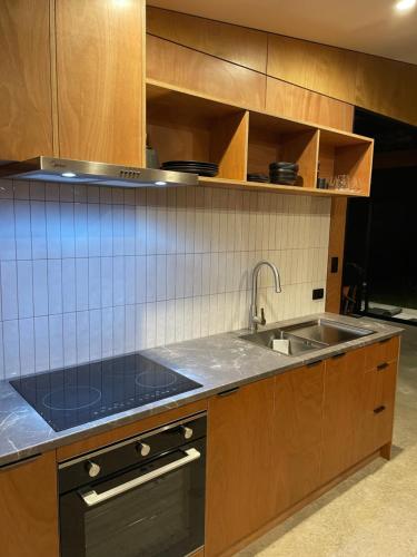 a kitchen with a sink and a stove at Studio Shed in The Paddocks in Oakura
