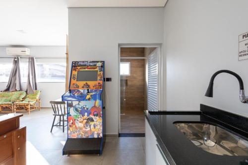 a kitchen with a refrigerator and a dining room at Casa Morada Da Praia, Paraiso em Bertioga - Condomínio à beira mar in Bertioga