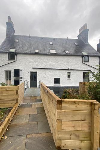 a house with a wooden ramp leading to a building at Somerled House in Portree