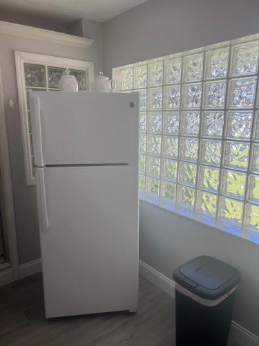 a white refrigerator and a trash can in a kitchen at Peaceful Florida Studio in Lakeland