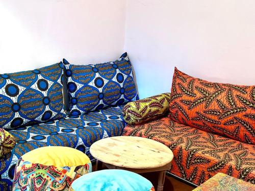 a living room with a couch with pillows and a table at Hippie Chic - Room La Dune in Sidi Kaouki