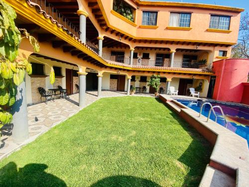 una casa con césped frente a una piscina en Hotel Sta Cruz Oaxtepec, en Oaxtepec