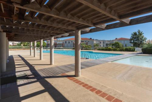 une terrasse avec une piscine et une pergola en bois dans l'établissement Le Jardin Secret by Golden Riviera, à Antibes