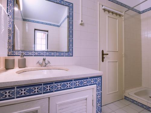 een badkamer met een wastafel en een spiegel bij Casa Porta da Vila in Óbidos