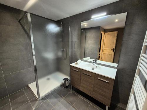 a bathroom with a shower and a sink and a mirror at La Residence - Appartement La résidence MAE-9451 in Vénosc