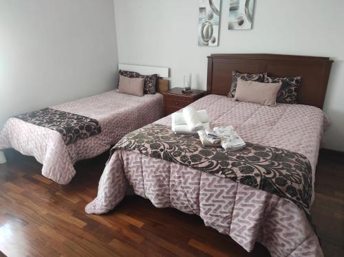 two beds in a room with wooden floors at Casa Lúcia in Nazaré