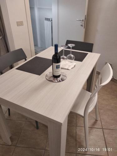a white table with a bottle of wine on it at La Dodicesima Luna in Peccioli
