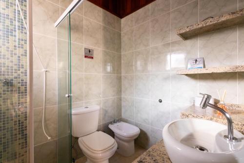 a bathroom with a toilet and a sink and a shower at Casa Morada Da Praia, Paraiso em Bertioga - Condomínio à beira mar in Bertioga