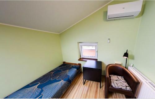 a small bedroom with a bed and a window at UROCZYSKO POD LASEM in Nickelswalde
