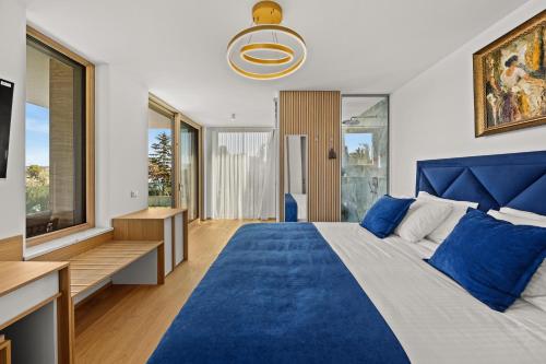 a bedroom with a blue bed and a television at Luxury Villa Con Brio in Pomer