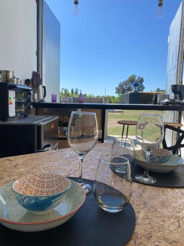 a table with two glasses and a bowl and a plate at containers house in San Rafael