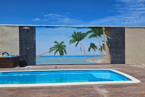 a swimming pool with a mural of the beach at Casa Praia seca!100 Metros Da Praia!Com Piscina! in Araruama